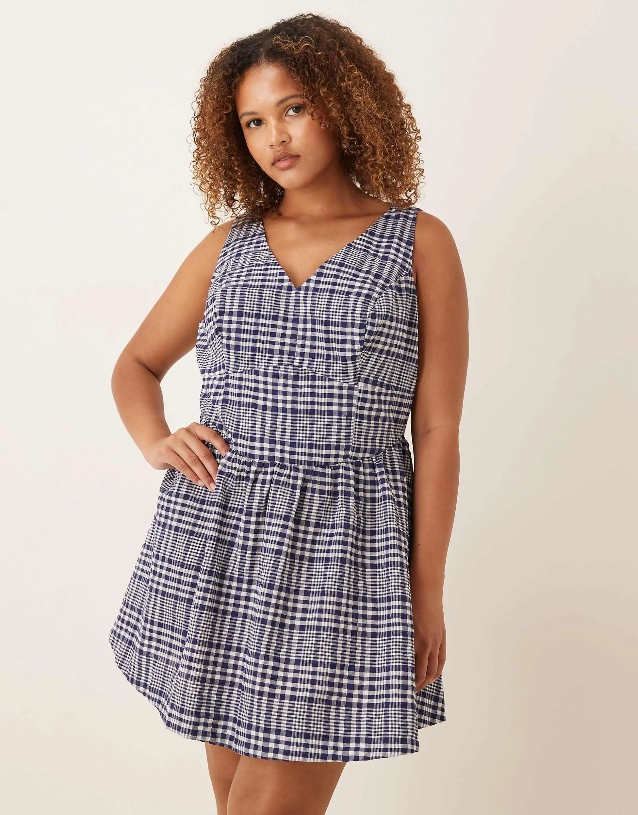 ASOS DESIGN Curve waisted v-neck mini sundress with seaming details in navy gingham 